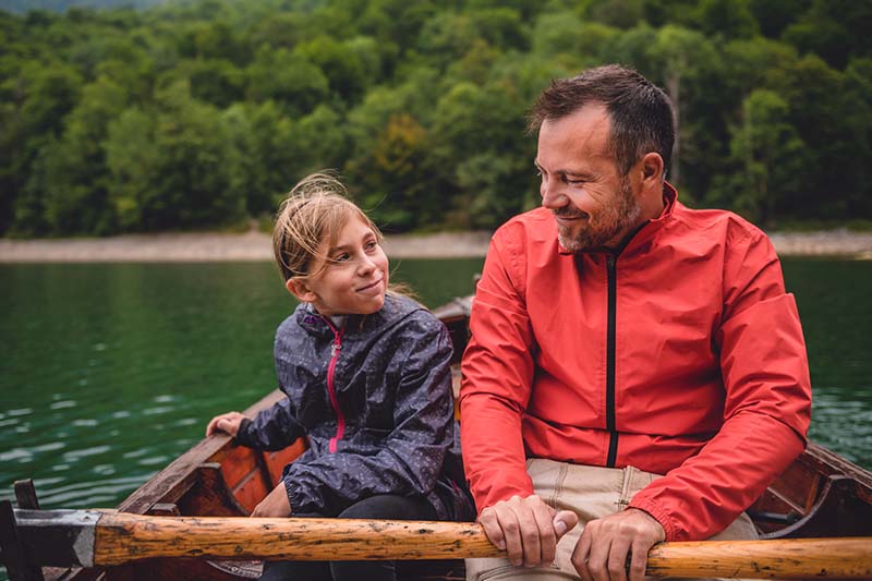 Dad and daughter row on a lake