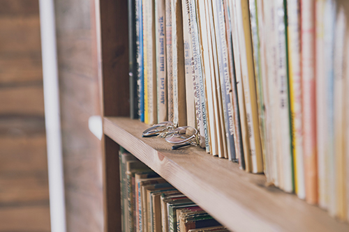 mari-potter-Zh0mcQuw_EQ-unsplash-sm A bookshelf with many books and a pair of glasses.