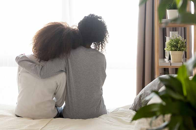 2025-08-20-acrf-mental-health-guide-800x533px Two people sit closely together on a bed looking away